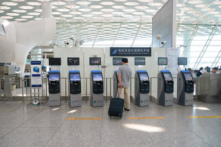 SHENZHEN, CHINA - CIRCA MAY, 2016: man use self check-in kiosk in Shenzhen Bao'an International Airport. It is located near Huangtian and Fuyong villages in Bao'an District, Shenzhen, Guangdong, China.のeditorial素材