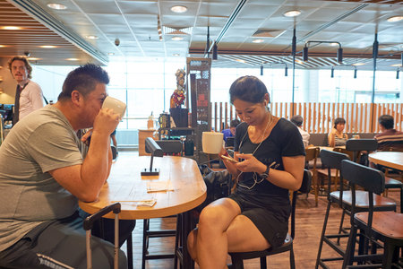 SINGAPORE - CIRCA NOVEMBER, 2015: customers in Starbucks at Singapore Changi Airport. Starbucks Corporation is an American global coffee company and coffeehouse chain.のeditorial素材
