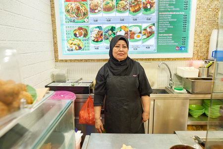 SINGAPORE - CIRCA NOVEMBER, 2015: indoor portrait of a worker at a foodcourt in Singapore Changi Airport. Changi Airport  is the primary civilian airport for Singapore.のeditorial素材