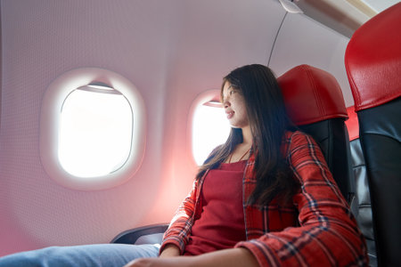 Young woman inside of a single-aisle aircraft.の写真素材