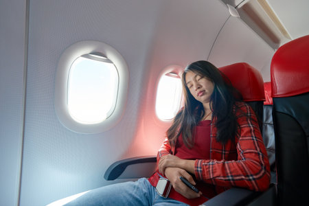 Young woman inside of a single-aisle aircraft.の写真素材