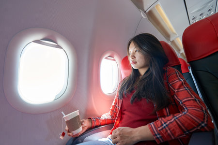 Young woman inside of a single-aisle aircraft.の写真素材