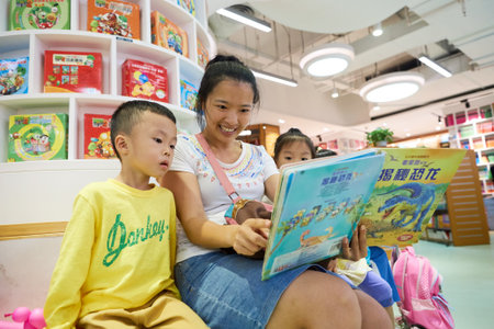 SHENZHEN, CHINA - SEPTEMBER 09, 2016: woman with children read book at a store in Shenzhen. Shenzhen is a major city in Guangdong Province, China.のeditorial素材