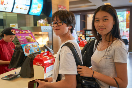 SHENZHEN, CHINA - OCTOBER 22, 2015: women stands at the counter inside a McDonald's restaurant. McDonald's is the world's largest chain of hamburger fast food restaurants.のeditorial素材