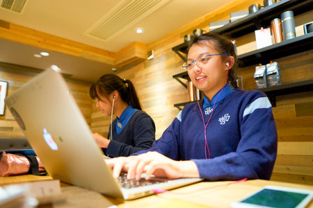 HONG KONG - CIRCA NOVEMBER, 2016: teenagers at a Starbucks cafe in Hong Kong. Starbucks Corporation is an American coffee company and coffeehouse chain.のeditorial素材