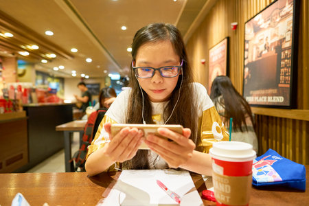 HONG KONG - CIRCA NOVEMBER, 2016: woman at Starbucks cafe in Hong Kong. Starbucks Corporation is an American coffee company and coffeehouse chain.のeditorial素材