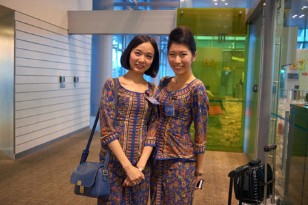 SINGAPORE - CIRCA NOVEMBER, 2015: indoor portrait of two pretty Singapore Airlines stewardesses at Changi Aiport.のeditorial素材