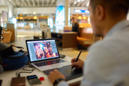 HONG KONG - CIRCA NOVEMBER, 2016: man processing photos at Hong Kong International Airport. It is the main airport in Hong Kong. The airport is located on the island of Chek Lap Kokのeditorial素材