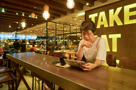 HONG KONG - CIRCA NOVEMBER, 2016: indoor portrait of a woman at Maxim's MX2 restaurant. Maxim's Caterers Limited is Hong Kong's largest food & beverage corporation and restaurant chain.のeditorial素材