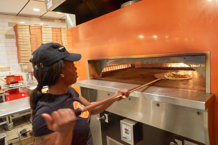 CHICAGO, IL - CIRCA MARCH, 2016: worker cook pizza at Blaze Pizza restaurant. Blaze Pizza LLC is a Pasadena, California-based chain within the fast-casual dining restaurants category.のeditorial素材