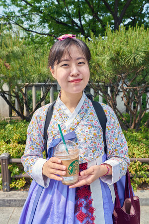 SEOUL, SOUTH KOREA - CIRCA MAY, 2017: woman with cup from Starbucks coffee shop in Seoul. Starbucks Corporation is an American coffee company and coffeehouse chain.のeditorial素材