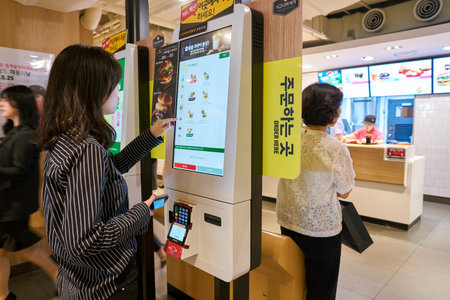 SEOUL, SOUTH KOREA - CIRCA MAY, 2017: woman use McDonald's ordering kiosk. McDonald's is an American...