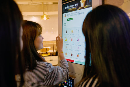 SEOUL, SOUTH KOREA - CIRCA MAY, 2017: women use McDonald's ordering kiosk. McDonald's is an American...