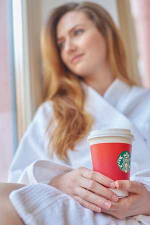 SAINT PETERSBURG, RUSSIA - CIRCA APRIL, 2017: woman with cup of coffee from Starbucks