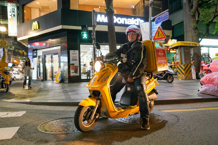 SEOUL, SOUTH KOREA - CIRCA MAY, 2017: man drive McDonald's delivery motorbike in Seoul. McDonald's is an American hamburger and fast food restaurant chain.のeditorial素材