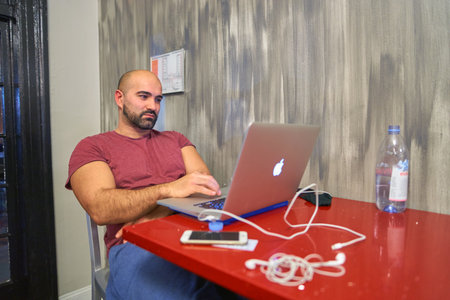 CHICAGO, IL, - CIRCA APRIL, 2016: man use notebook at Chicago Getaway Hostel. Hostels provide budget-oriented, sociable accommodation where guests can rent a bed, usually a bunk bed, in a dormitory.のeditorial素材
