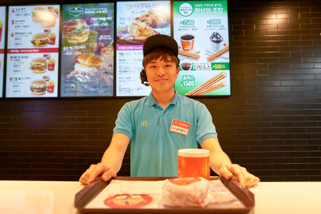 BUSAN, SOUTH KOREA - CIRCA MAY, 2017: worker at McDonald's. McDonald's is an American hamburger and fast food restaurant chain.のeditorial素材