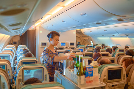 SINGAPORE - NOVEMBER 03, 2015: flight attendant serve food and drinks to passengers on board of Singapore Airlines Airbus A380のeditorial素材
