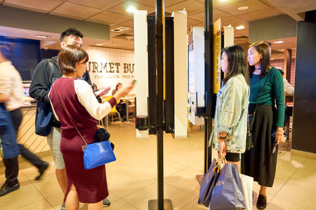 HONG KONG - CIRCA NOVEMBER, 2016: women use a Mcdonald's ordering kiosks in Hong Kong. McDonald's is...