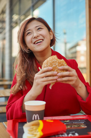KALININGRAD, RUSSIA - CIRCA OCTOBER, 2017: pretty woman eat at McDonald's restaurant.のeditorial素材