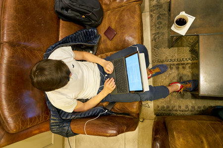 SAINT PETERSBURG, RUSSIA - CIRCA OCTOBER, 2017: man using gadget in a Starbucks coffee shop in Saint Petersburg. Starbucks Corporation is an American coffee company and coffeehouse chain.のeditorial素材