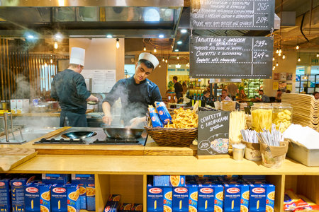 SAINT PETERSBURG, RUSSIA - CIRCA AUGUST, 2017: man expertly prepare the food in wok at Marketplace restaurant.のeditorial素材