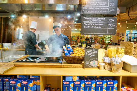 SAINT PETERSBURG, RUSSIA - CIRCA AUGUST, 2017: man expertly prepare the food in wok at Marketplace restaurant.のeditorial素材