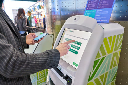MILAN MALPENSA, ITALY - CIRCA NOVEMBER, 2017: a passenger use Alitalia self service check-in kiosks...