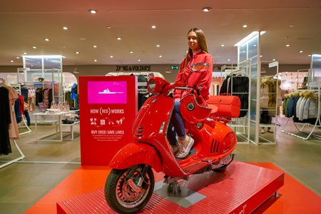 MILAN, ITALY - CIRCA NOVEMBER, 2017: young woman poses with a scooter at Rinascente shopping center...