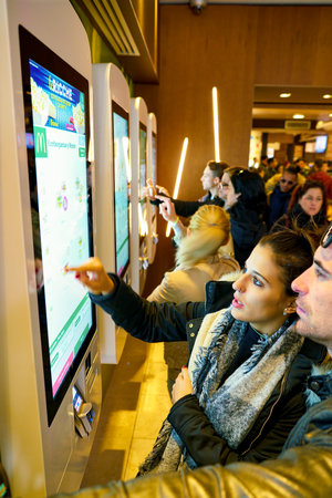 MILAN, ITALY - CIRCA NOVEMBER, 2017: customers at a McDonald's store place orders and pay through...