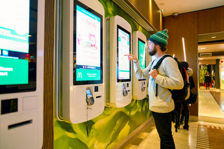 MILAN, ITALY - CIRCA NOVEMBER, 2017: customer at a McDonald's store place orders and pay through self ordering kiosk.