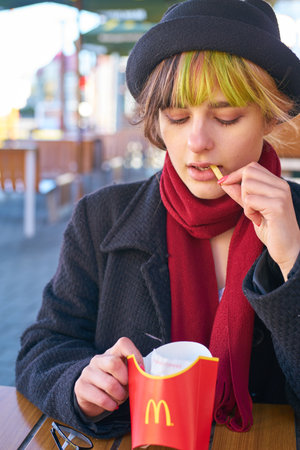 KALININGRAD, RUSSIA - CIRCA APRIL, 2018: caucasian woman eats at McDonald's restaurant in...