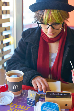 KALININGRAD, RUSSIA - CIRCA APRIL, 2018: caucasian woman with breakfast on tray at McDonald's restaurant in Kaliningrad.のeditorial素材