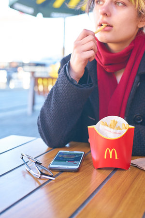 KALININGRAD, RUSSIA - CIRCA APRIL, 2018: caucasian woman eats at McDonald's restaurant in Kaliningrad.のeditorial素材
