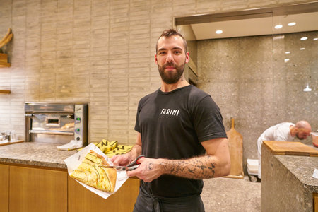 MILAN, ITALY - CIRCA NOVEMBER, 2017: indoor portrait of a man at Farini in Milan. Farini is modern bakery which offers Italian pastry, salads, bowls and pizzaのeditorial素材