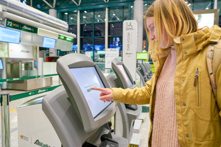 ROME, ITALY - CIRCA NOVEMBER, 2017: woman use self check-in kiosks in Fiumicino International...