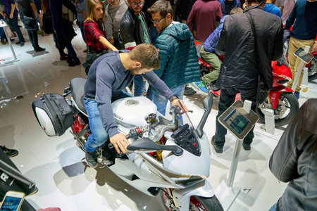 MILAN, ITALY - NOVEMBER 11, 2017: a visitor try out a motorcycle at the EICMA 2017 - 75th International Motorcycle Exhibition.のeditorial素材
