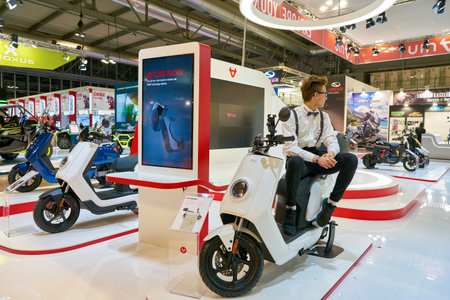 MILAN, ITALY - NOVEMBER 11, 2017: a model poses with a scooter for the visitors during the EICMA...
