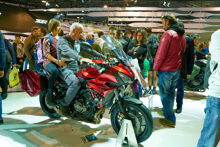 MILAN, ITALY - NOVEMBER 11, 2017: visitors try out a motorcycle at the EICMA 2017 - 75th...