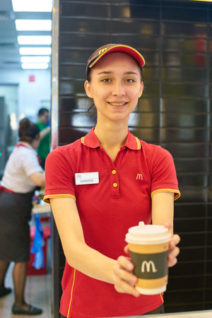 KALININGRAD, RUSSIA - CIRCA SEPTEMBER, 2018: woman hold paper cup with coffee in McDonald's...