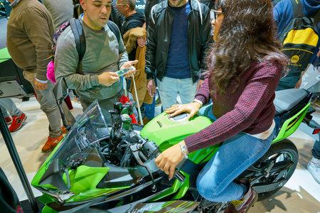 MILAN, ITALY - NOVEMBER 11, 2017: visitors try out a motorcycle at the EICMA 2017 - 75th...