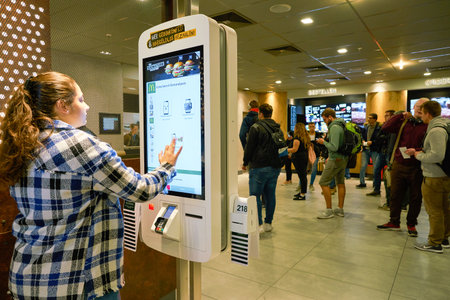 DUSSELDORF, GERMANY - CIRCA SEPTEMBER, 2018: woman use self ordering kiosk at McDonald's restaurant.