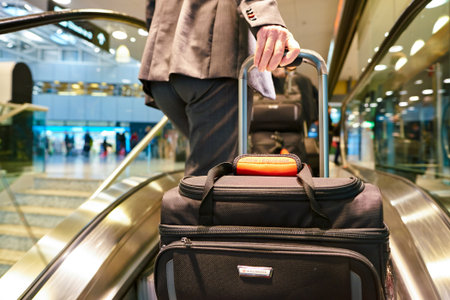 ZURICH, SWITZERLAND - CIRCA OCTOBER, 2018: flight attendant with baggage on escalator at Zurich International Airport.のeditorial素材