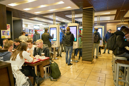 MOSCOW, RUSSIA - CIRCA OCTOBER, 2018: people use self-ordering kiosks at McDonald's restaurant.