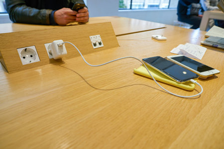 COLOGNE, GERMANY - CIRCA OCTOBER, 2018: a phone charging at Apple store in Cologne.のeditorial素材