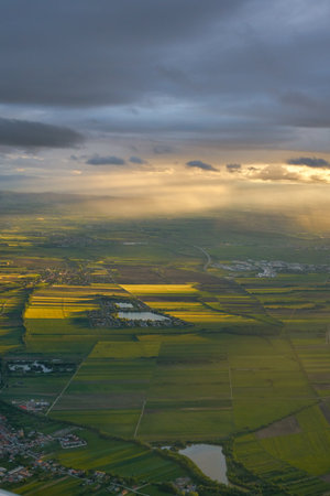 Scenic aerial landscape view of green fields in rural countryside during sunset