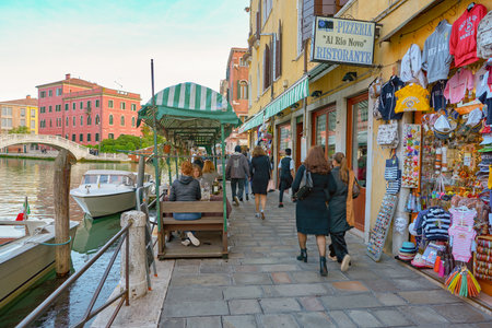 VENICE, ITALY - CIRCA MAY, 2019: a restaurant at a canal waterfront in Venice in the evening.のeditorial素材