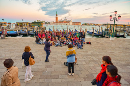 VENICE, ITALY - CIRCA MAY, 2019: people posing for take a group photo at waterfrong in Venice.