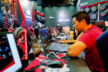 SHENZHEN, CHINA - CIRCA APRIL, 2019: a man using a laptop at Asus ROG Store in Shenzhen. Republic of...