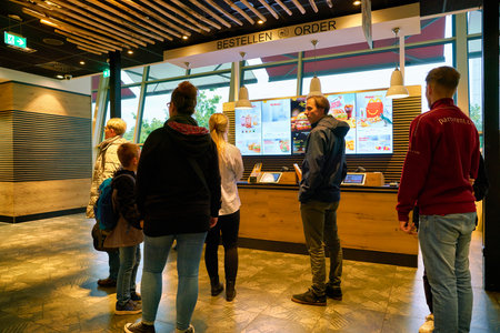 BERLIN, GERMANY - CIRCA SEPTEMBER, 2019: people staying in queue at McDonald's restaurant in Berlin.